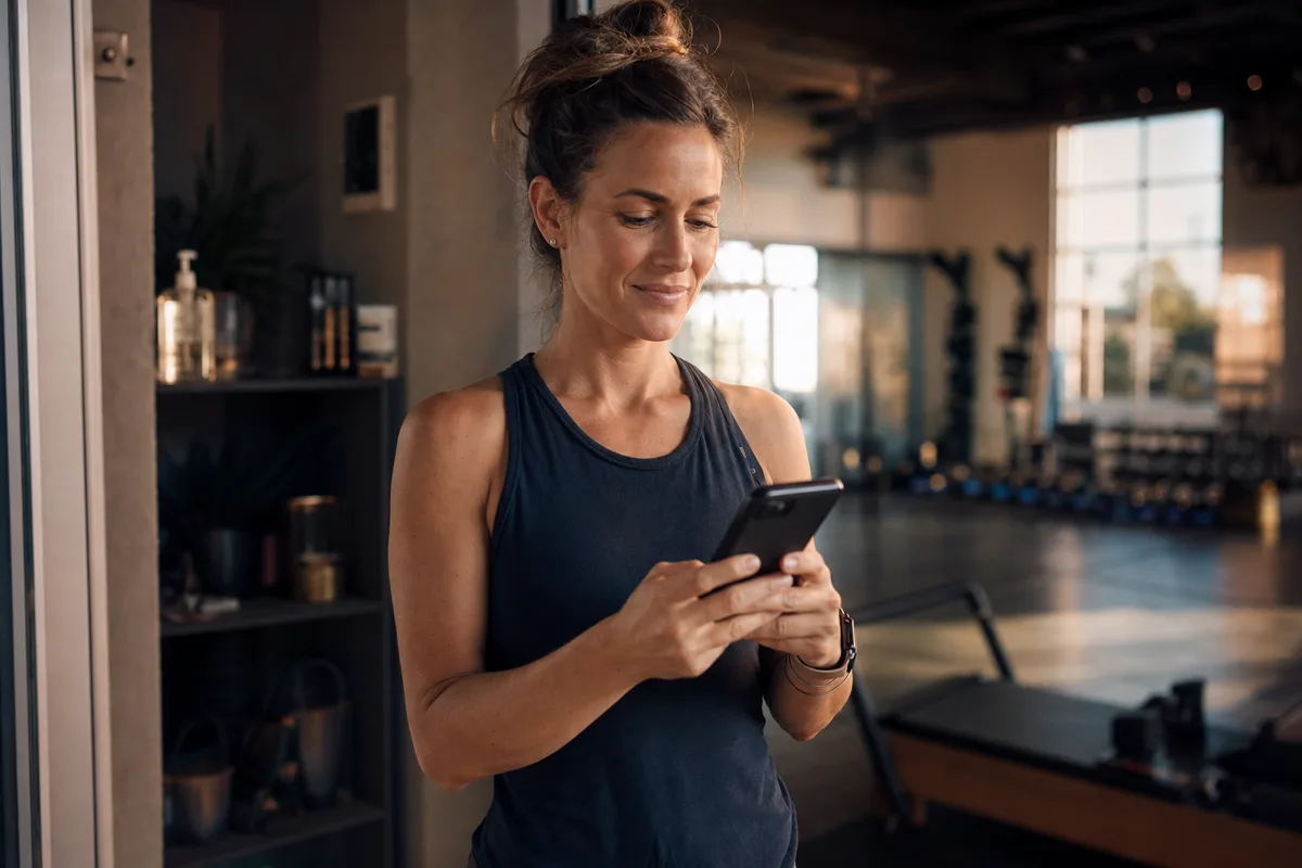 A small business owner checking Facebook ad results on her phone inside her own studio